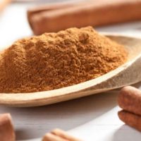 cinnamon powder in a wooden spoon